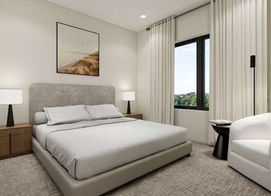 A bedroom with a large bed, a chair, and a painting on the wall.