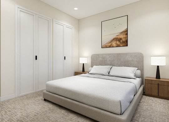 A bedroom with a large bed, two lamps, and a painting on the wall.