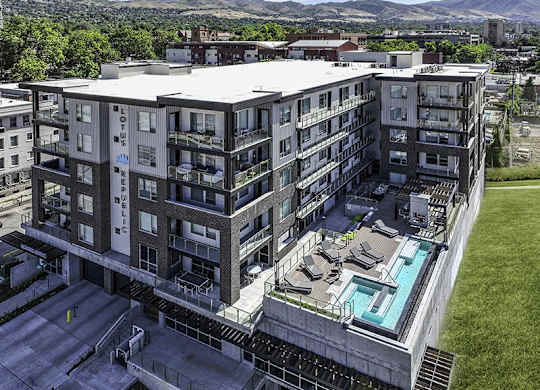 A large apartment complex with a pool in the middle.