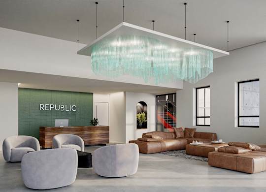 A modern living room with a large sofa, armchairs, and a glass chandelier.