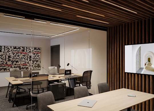 A conference room with a long table and chairs, a laptop on the table, and a large screen displaying a green object.