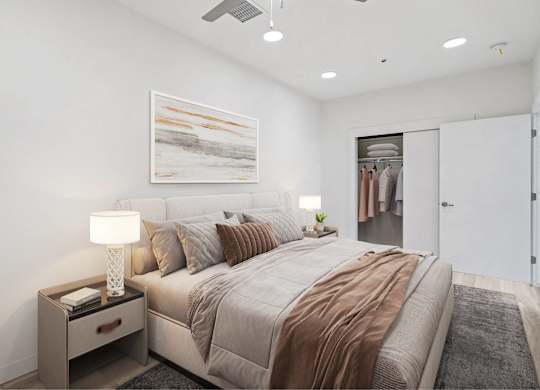 A bedroom with a bed, nightstand, and a painting on the wall.
