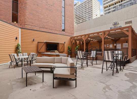 A patio with a couch, chairs, and a table.