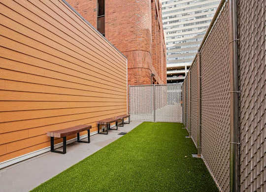A long corridor with benches and a fence.