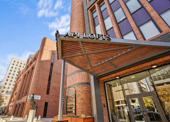 A modern building with a red brick facade and a sign that reads