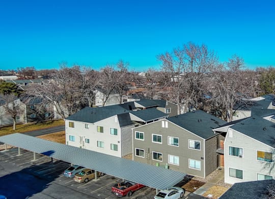A large apartment complex with a parking lot in front.