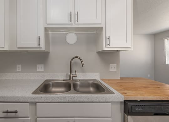 A kitchen with a sink and a stove top oven.