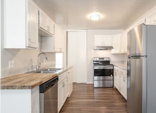 A kitchen with white cabinets and stainless steel appliances.