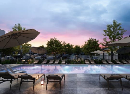 a swimming pool with lounges and a sunset