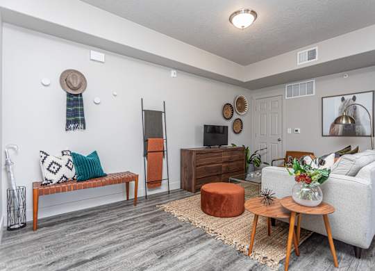 A living room with a white couch, a wooden coffee table, and a rug on the floor.