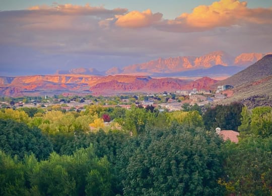 a city with mountains in the background and trees in the foreground