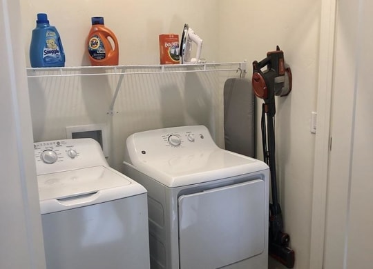 two washer and dryers in a small laundry room