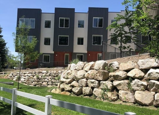 an apartment building with large rocks in front of it