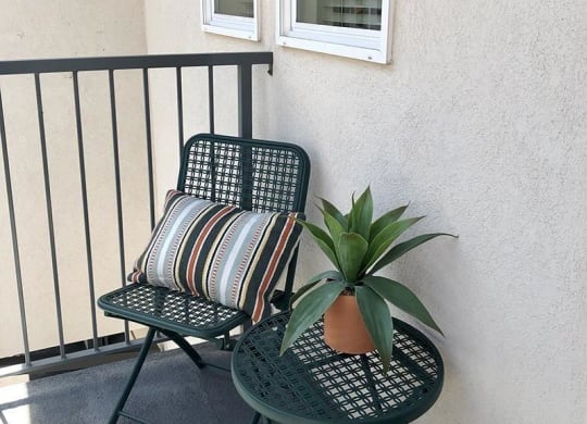 a balcony with a chair and a potted plant