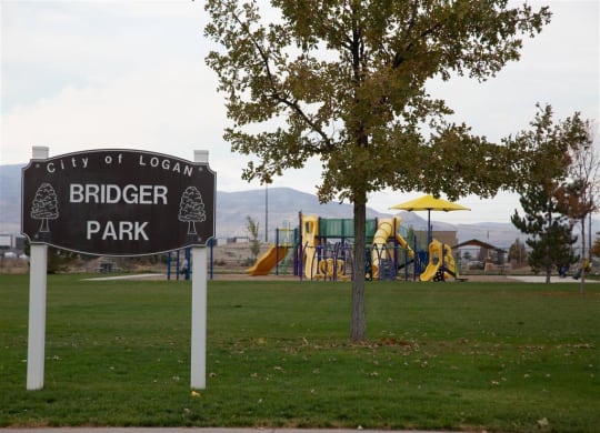 a city birder park sign in front of a playground