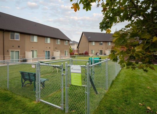 a fenced in yard with a playground and apartment buildings