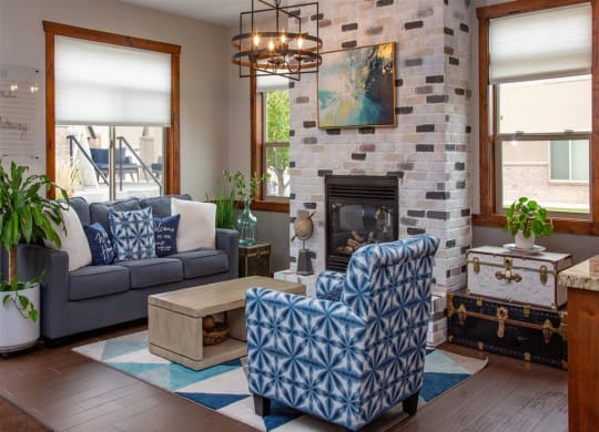 a living room with blue and white furniture and a stone fireplace