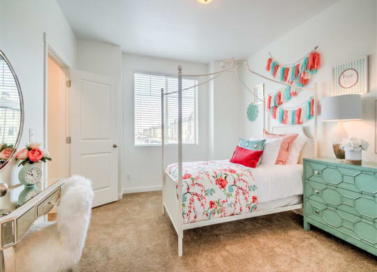 a bedroom with a bed and a dresser and a window at Aderra apartment complex for rent in Roy, Utah