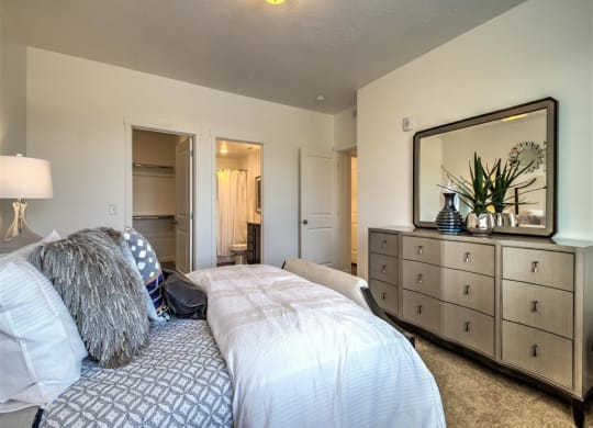 a bedroom with a bed and a yellow wall at Aderra apartments in Roy, Ut