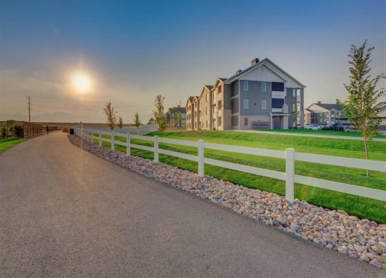 a road leading to a house with a white fence  at Affinity 56 Apartments in West Jordan, Utah
