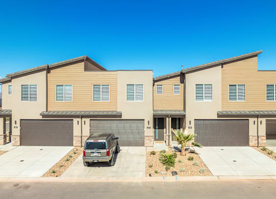A row of modern houses with garages and driveways.