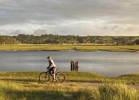 a man riding a bike next to a body of water