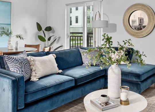 a living room with a blue couch and a white coffee table