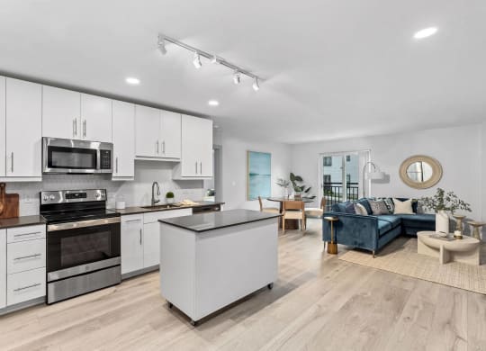 an open kitchen and living room with white cabinets
