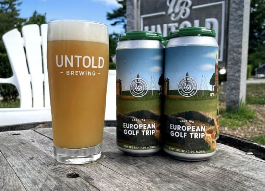 two cans of union brewing and a glass of beer on a table