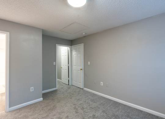 an empty room with two doors and a carpeted floor at Avon Crossings, Durham North Carolina