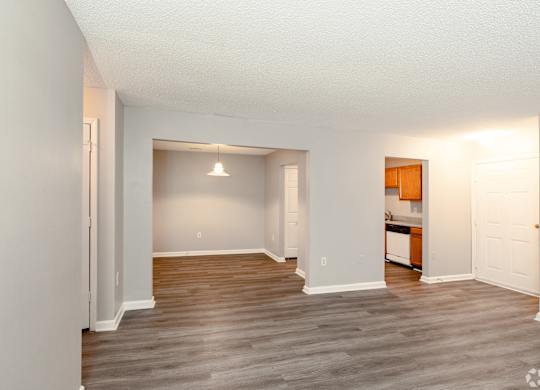 an empty living room with wood flooring and a kitchen at Avon Crossings, Durham North Carolina