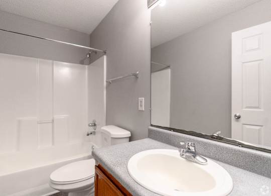 a bathroom with a mirror and a sink and a toilet at Avon Crossings, Durham, NC