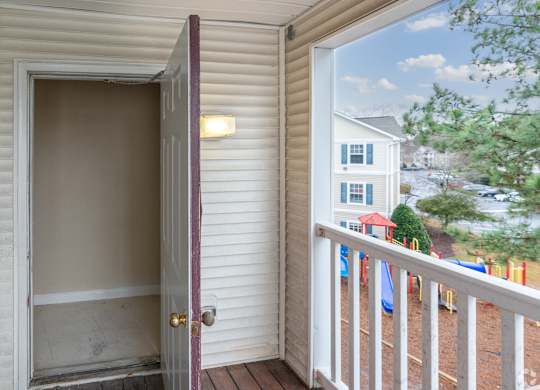 a door open to a balcony with a house in the background at Avon Crossings, Durham, NC