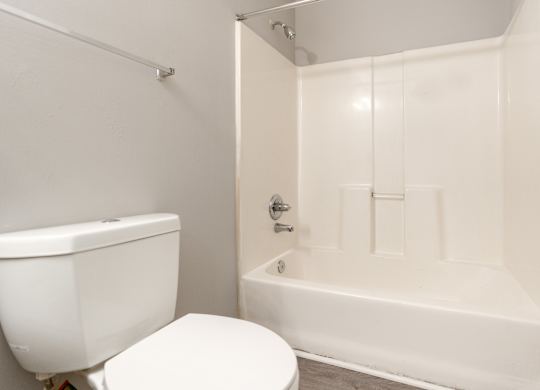 a white bathroom with a toilet and a tub at Avon Crossings, Durham
