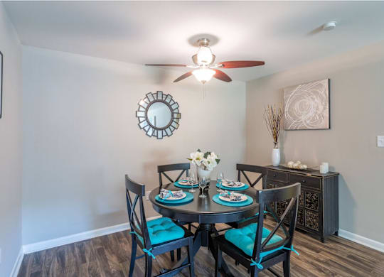 a dining room with a table and chairs and a ceiling fan at Bradley Square, North Charleston