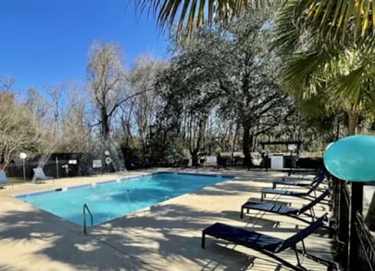 a swimming pool with benches and trees in the background at Bradley Square, North Charleston, SC 29406