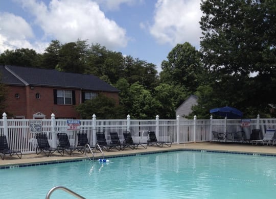 a resort style pool with chairs and a fence around it at Brookside Pointe, Travelers Rest, 29690