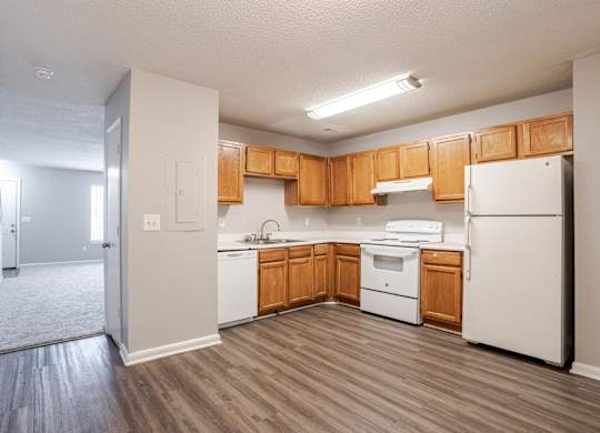 A kitchen with white appliances and wooden cabinets.at Brookside Pointe Apartments, Travelers Rest South Carolina