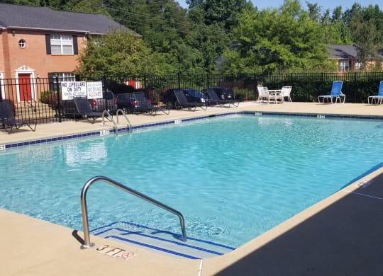a swimming pool with chairs around it in front of a house at Brookside Pointe, Travelers Rest, SC 29690