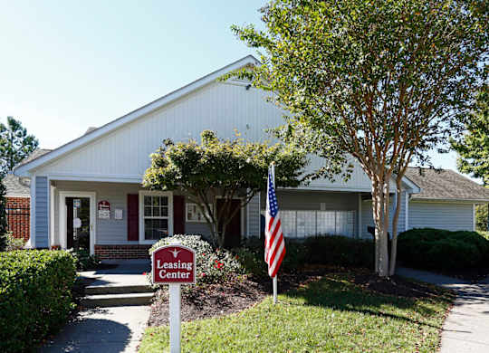 a house with an american flag and a leasing sign in front of it