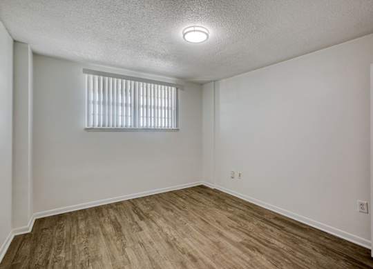a bedroom with white walls and a window