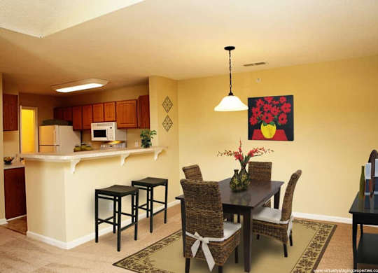 A kitchen with a dining table and chairs.