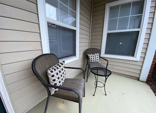 A patio with a chair and a small table.