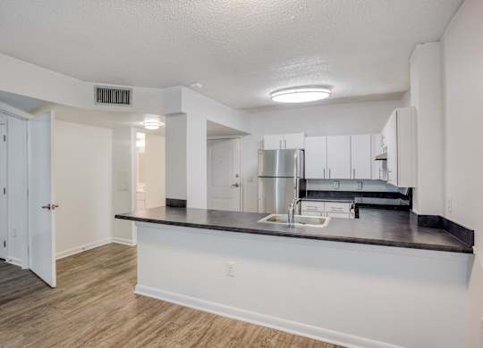 a kitchen with a large island and a stainless steel refrigerator