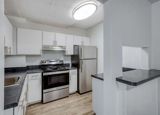 a kitchen with white cabinetry and stainless steel appliances