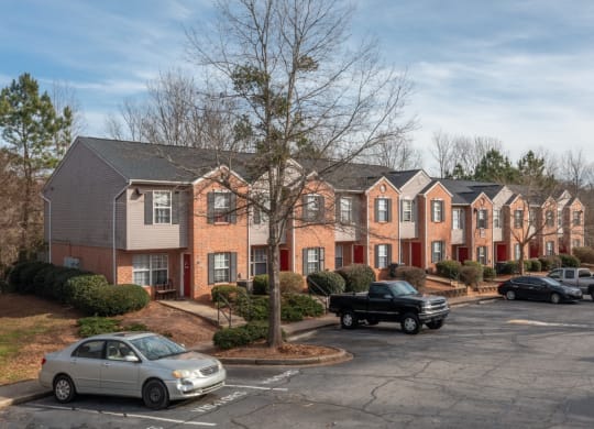 a row of apartment buildings with cars parked in a parking lot at Canaan Pointe, Greenville, 29607