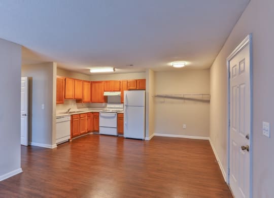 an empty kitchen with wood flooring and white appliances at Canaan Pointe, Greenville, SC 29607