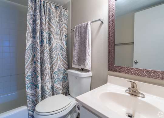 A white toilet sits next to a sink in a bathroom.at Bradley Square, North Charleston South Carolina