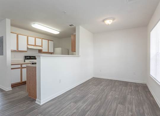 A kitchen with white walls and wooden floors.at The Regency Apartment Homes, Manassas