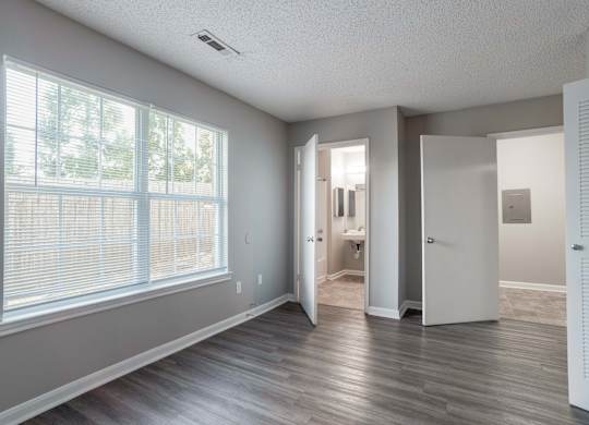 A room with a large window at Jamestown Pointe Apartments, South Carolina 